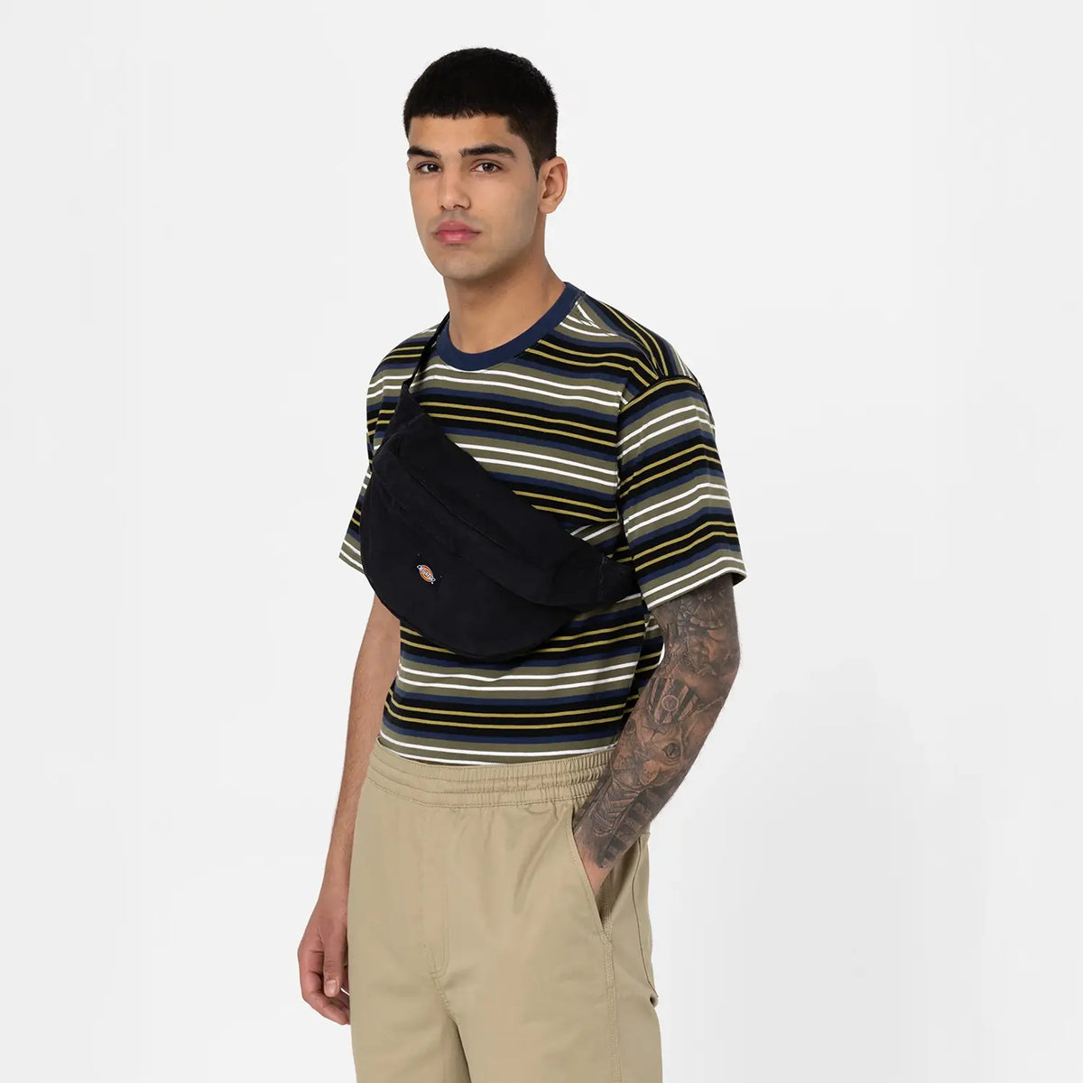 Person trägt die Dickies Duck Canvas Cross Body 32 cm in Schwarz über der Schulter