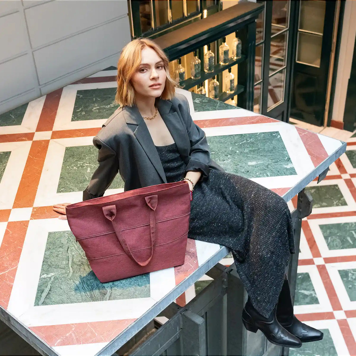 Lifestyle-Aufnahme Reisenthel Shopping Shopper e1 Twist Maroon – stilvolle Tragetasche für Stadt und Reisen